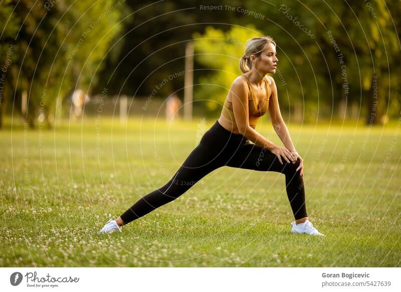 Pretty young woman stretching in the park fit fitness female person exercise training summer nature health lifestyle outdoors workout beauty spring beautiful