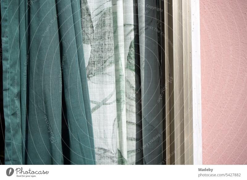 Curtains and curtains in green and with leaf pattern in the sunshine behind the window pane of an old building in Seehofstraße in the district of Sachsenhausen in Frankfurt am Main in Hesse, Germany