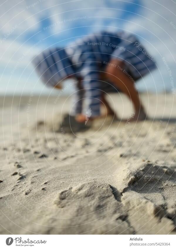 Sand on beach, child in striped bathrobe playing in background Beach Child Playing Bathrobe blurriness Summer Ocean Vacation & Travel coast Summer vacation