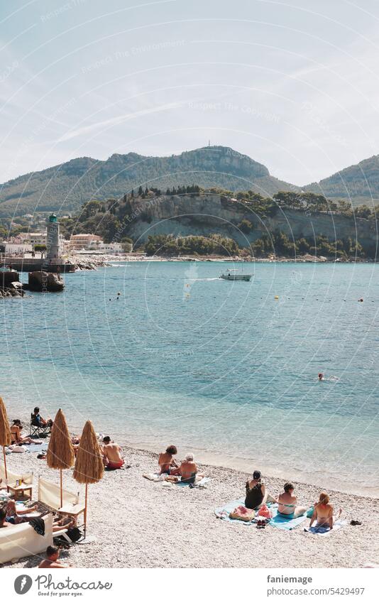 Plage du Bestouan Strand von Cassis mit Leuchtturm im Hintergrund Mittelmeer Sonnenschirme Badegäste Urlauber Kiesstrand klares Wasser türkis Südfrankreich