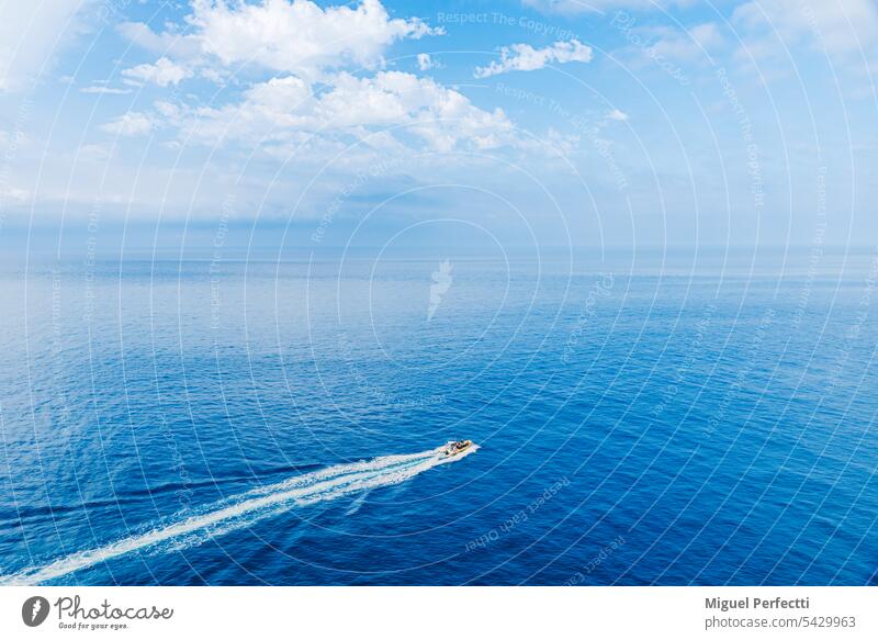 Outboard boat entering the blue waters of the Mediterranean, Granada coast. mediterranean sea speedboat maro - costa del sol travel destination horizon