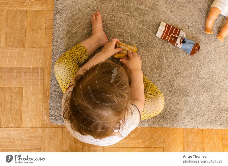 Toddler from above trying to put on socks Put on socks montessori Sit Attract feet Documentary Photos of everyday life Child from on high