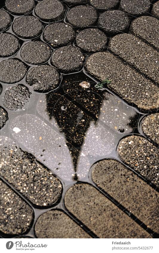 Church spire reflected in a small puddle Puddle puddle mirroring Cobblestones Rain Town urban grey day City walk Wet Water Street Exterior shot reflection