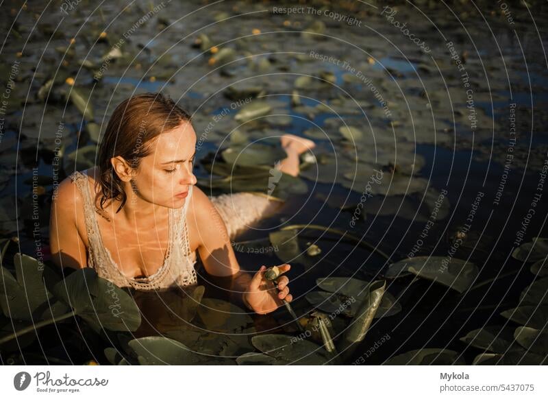 Beautiful sexy girl in white dress posing in river pond with water lilies. Fairytale story about ophelia model lily pretty wet caucasian female woman young