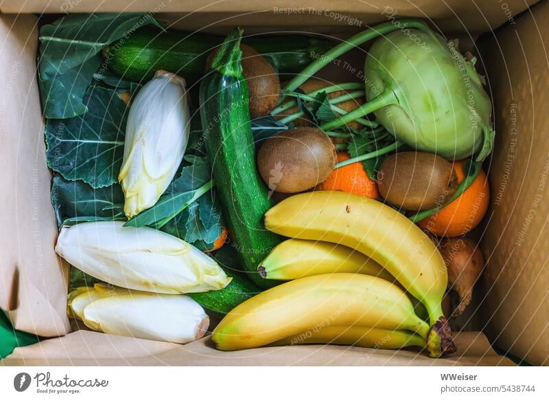 A box full of fruit and vegetables, fresh, natural and appetizing Vegetable Crate Cardboard delivery delivery service Bananas Kohlrabi Chicory Zucchini