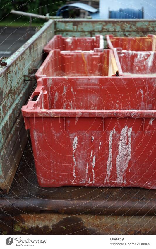 Red plastic containers on the flatbed of a rusty old trailer on the farm of a winegrower in Traben-Trarbach on the Moselle in the Bernkastel-Wittlich district of Rhineland-Palatinate, Germany