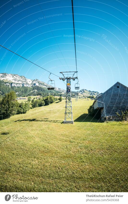 Chairlift leads past alpine hut over meadows Meadow chair lift Chair lift House (Residential Structure) alphabet Pole Cable Rope Willow tree Mountain Sky Alps