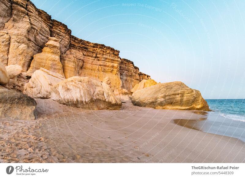 Rocks and sand by the sea in the evening Moody Sand Beach stones Water coast Oman Sky Clouds Ocean Landscape Horizon Nature Blue Summer Tourism Bay vacation