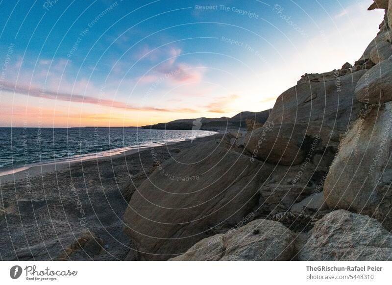 Rocks and sand by the sea in the evening Moody Sand Beach stones Water coast Oman Sky Clouds Ocean Landscape Horizon Nature Blue Summer Tourism Bay vacation