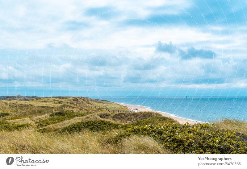 Landscape on Sylt island with the North Sea and the marram grass hills background beach beautiful blue bright cloudy coast coastline color dunes empty