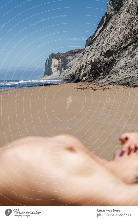 A very summerish frame with a gorgeous naked girl relaxing on a nude beach in Corfu, Greece. The vacation mood is on and all the sexiness is in the air. Sexy curves, nipples out, a bit out of focus.