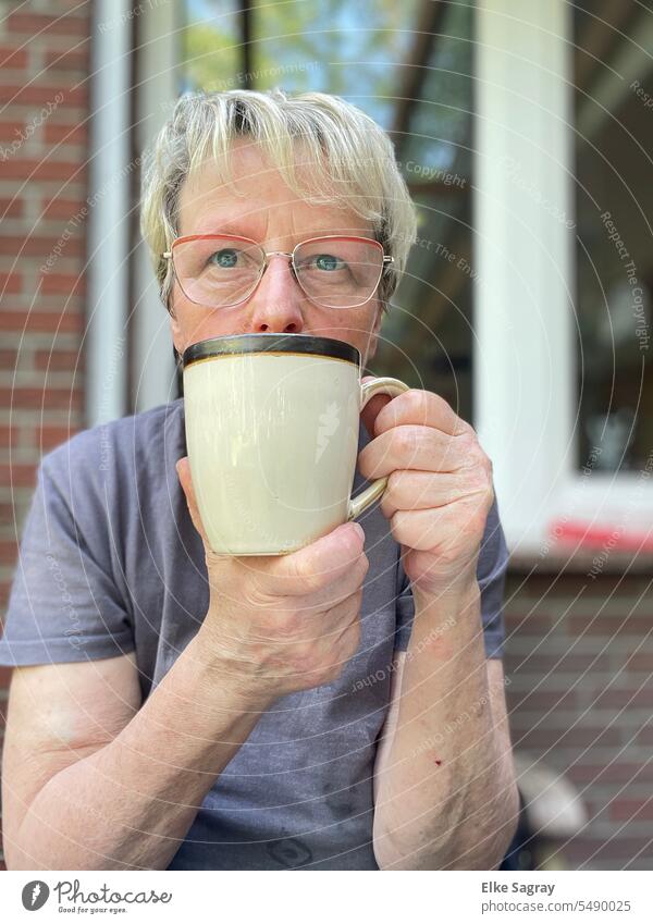 Dreaming woman in front of the window with coffee cup Woman portrait Feminine Exterior shot Young woman Colour photo Face Human being Shallow depth of field