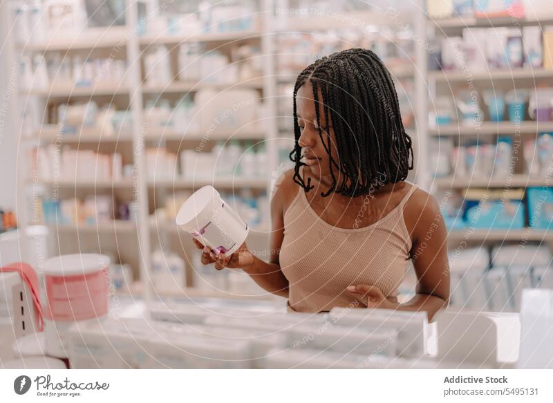 Black woman reading information on drug bottle at store buy customer pharmacy drugstore confident young product client medicine prescription lifestyle