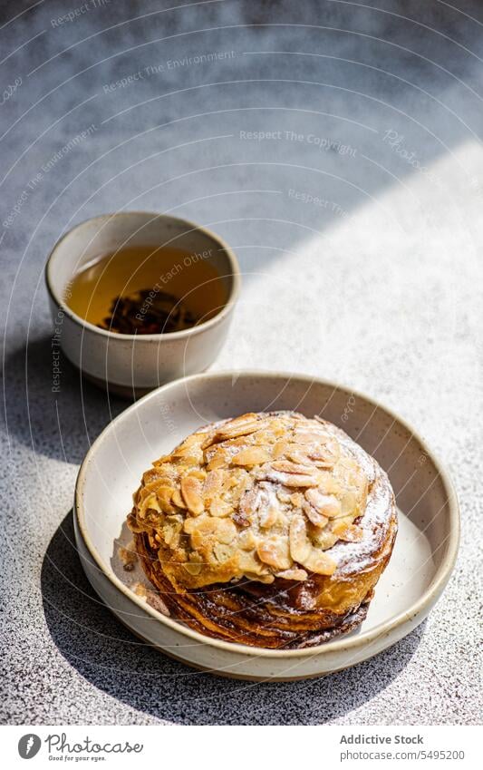 Sweet almond pastry on the plate with cup of green tea sweet dish surface table high angle from above food drink dessert eat yummy appetizing delicious homemade