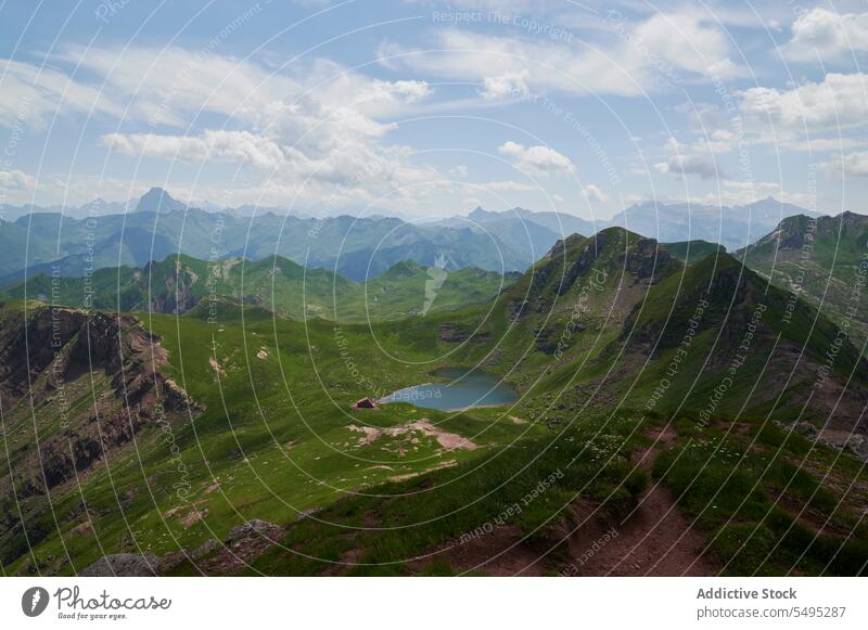 Scenic view of mountain and valley with pond picturesque pyrenees range landscape nature highland cloudy grass blue sky spain green scenery water environment