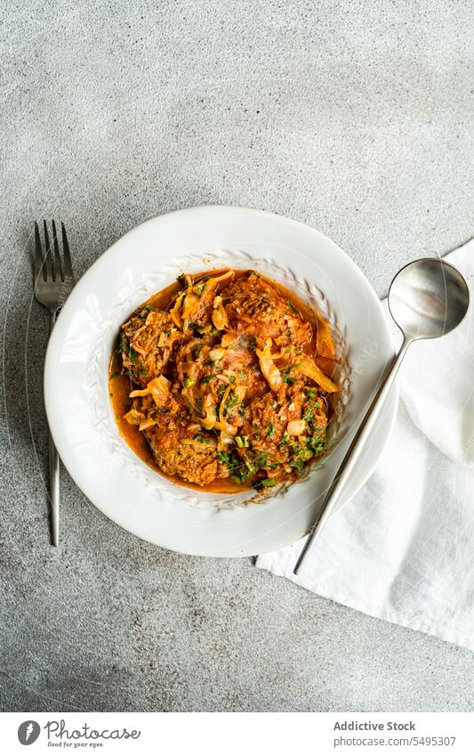 Georgian Gupta dish of meatballs with rice stewed in tomato sauce with cabbage, carrot and onion, served with chopped coria georgian gupta spoon fork plate