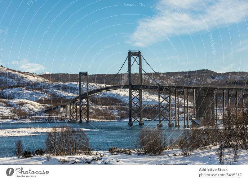 Suspension bridge over river in winter day suspension mountain snow picturesque amazing spectacular breathtaking nature blue sky scenery wintertime landscape