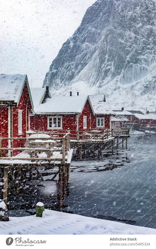 Small village on snowy shore of lake house settlement winter river mountain majestic landscape norway lapland lofoten island north atlantic nordic arctic hill