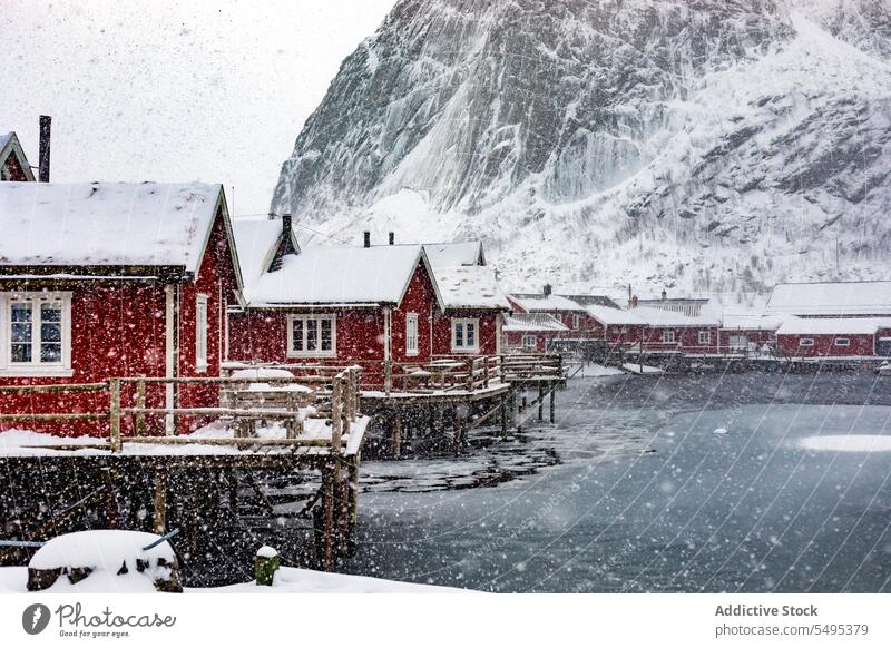 Small village on snowy shore of lake house settlement winter river mountain majestic landscape norway lapland lofoten island north atlantic nordic arctic hill