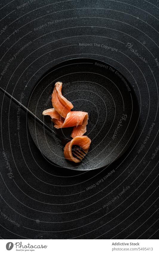 Healthy salmon slice on dark plate dish healthy food black dark background table surface yummy fresh nutrition nutrient fork menu darkness high angle from above