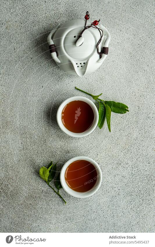 Tea set in Asian style with lemon leaves as decoration tea asian leaf table surface gray cup full drink beverage liquid jar ceramic green white brown isolated