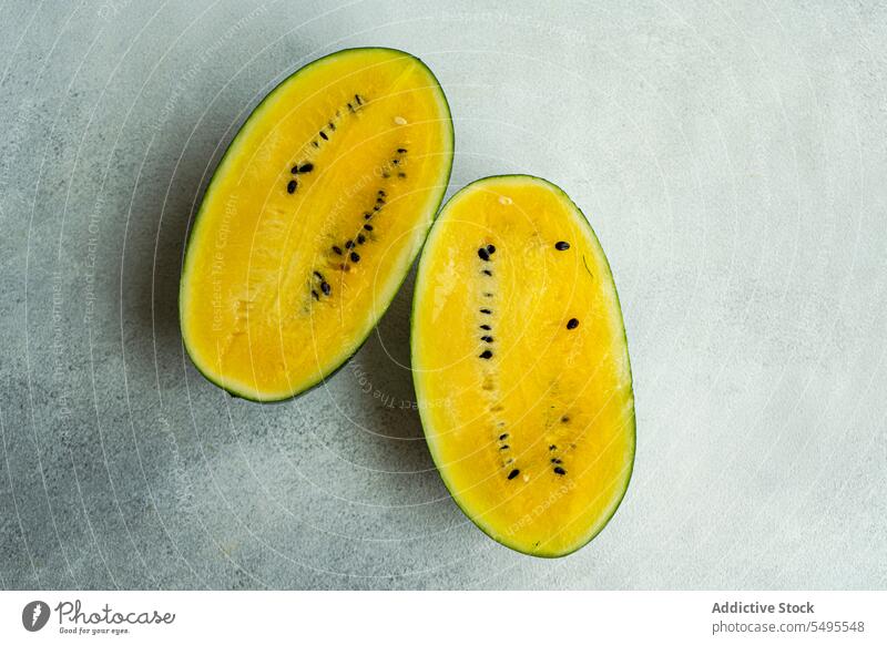 Organic yellow watermelon organic slice cut piece table surface background gray background high angle from above top view fruit food fresh healthy blur eat