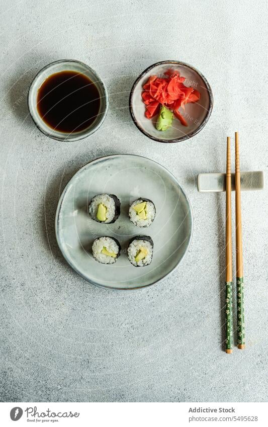 Top view of japanese food placed on a white concrete table serve set sushi roll bowl salmon rice seaweed soy sauce asian food chopstick healthy cookery culinary