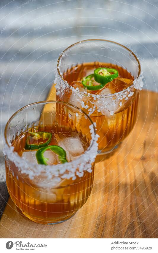 Japanese sochu liquor with mango juice and slices of Jalapeno pepper with salt on the glass edge jalapeno japanese traditional drink liquid beverage wooden