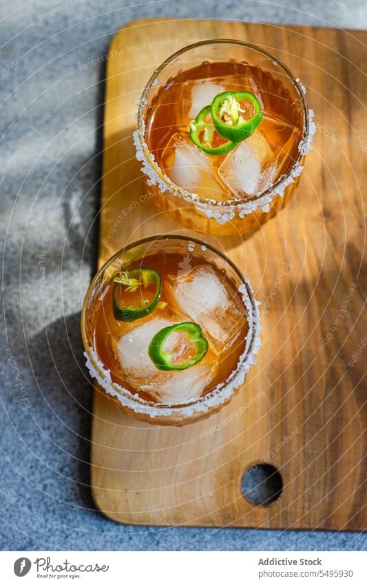 Japanese sochu liquor with mango juice and slices of Jalapeno pepper with salt on the glass edge jalapeno japanese traditional drink liquid beverage wooden