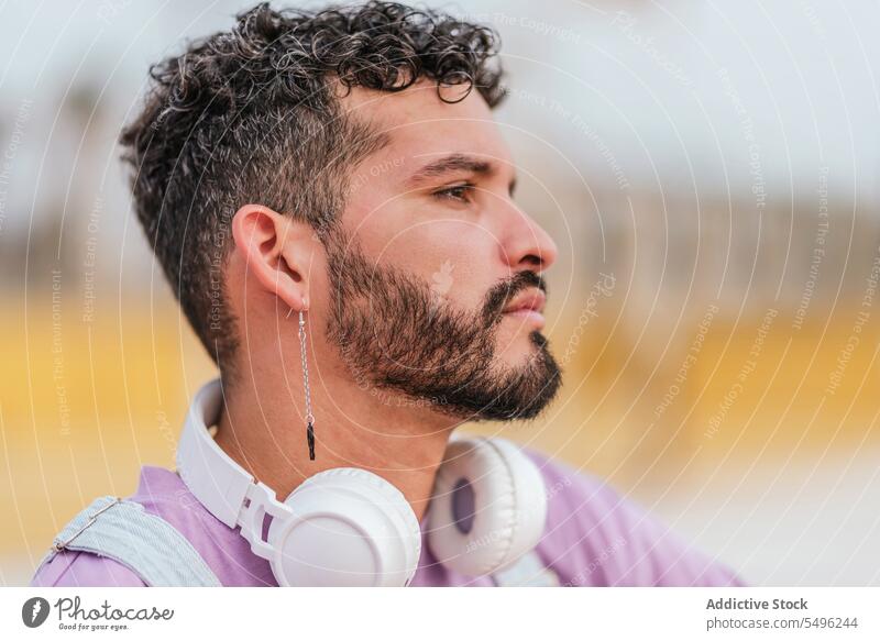 Serious young bearded man looking away pensive thoughtful serious sit unshaven alone headshot concentrate outfit focus serene unemotional think ponder style