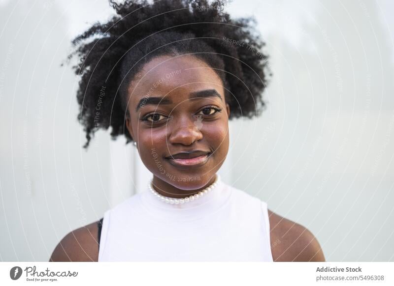 Smiling black teenage girl in white dress teenager positive hairstyle smile hairdo happy portrait slim young afro female african american lady casual glad