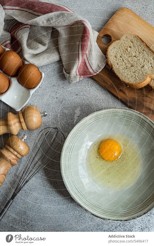 Raw egg in bowl with various ingredients in kitchen cook eggs culinary break cuisine recipe raw prepare food cutting board table pepper seasoning flavoring