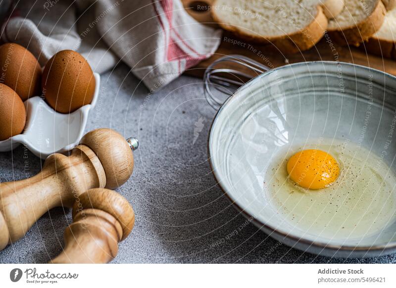 Raw egg in bowl with various ingredients in kitchen cook eggs culinary break cuisine recipe raw prepare food cutting board table pepper seasoning flavoring