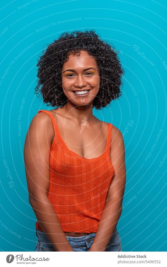 Optimistic black woman with Afro hairdo fashion model afro curly hair friendly optimist smile portrait female african american charismatic candid sincere