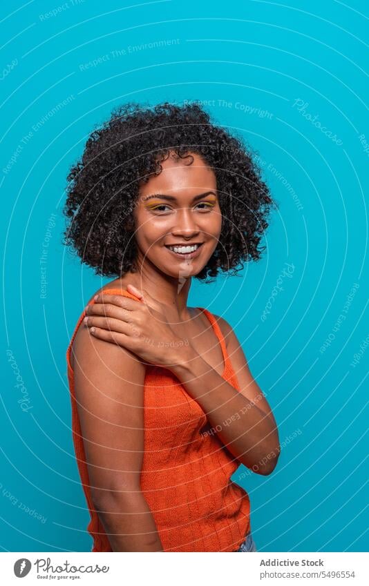 Optimistic black woman with Afro hairdo fashion model afro curly hair friendly optimist smile portrait female african american charismatic candid sincere