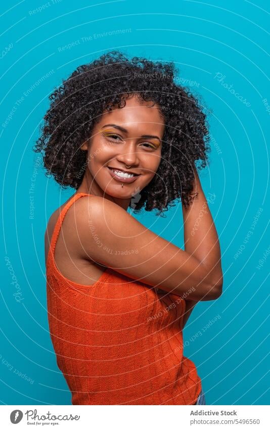 Optimistic black woman with Afro hairdo fashion model afro curly hair friendly optimist smile portrait female african american charismatic candid sincere