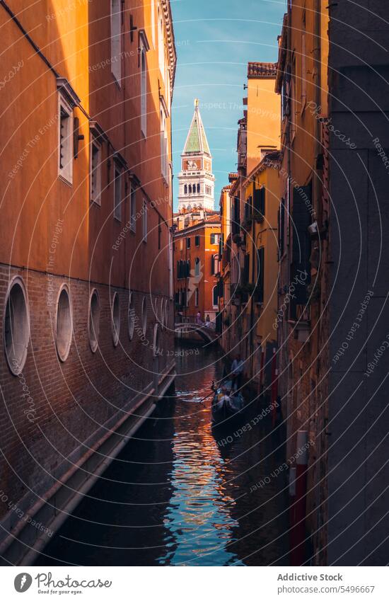 Old city channel with traditional gondola in sunlight canal architecture tower scenery residential facade cityscape historic travel building sightseeing