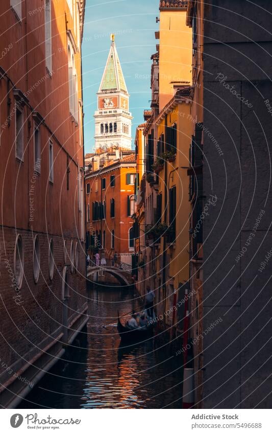 Old city channel with traditional gondola in sunlight canal architecture tower scenery residential facade cityscape historic travel building sightseeing