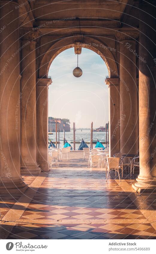 Arched passage of Biblioteca Marciana library of saint mark biblioteca marciana arch column gondola docked colorful picturesque san marco basin marciana library