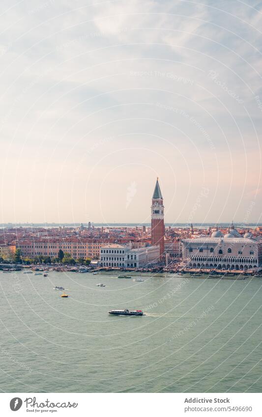 Boats floating on channel near historic buildings in sunlight architecture basilica canal vaporetto sightseeing landmark culture city sunset tower church venice