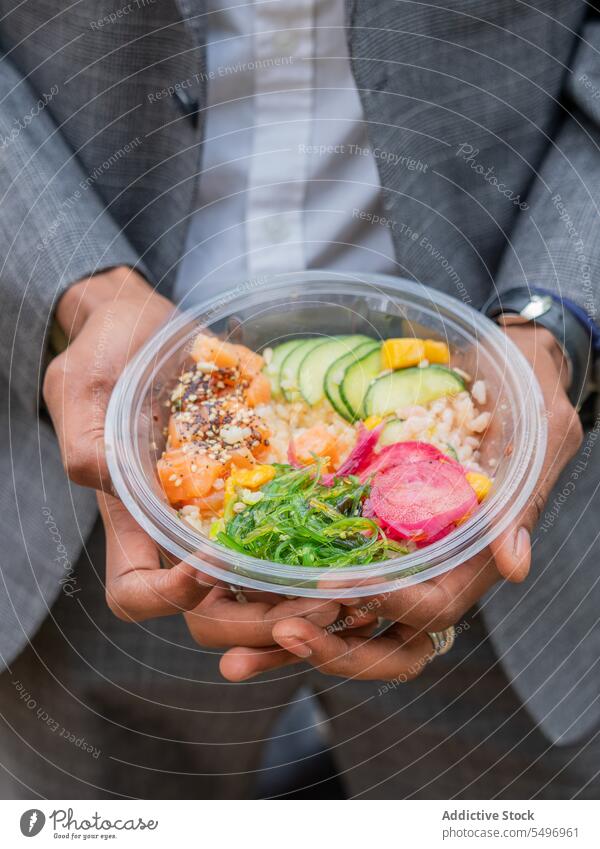 Unrecognizable man showing bowl with salad in daylight vegetable fish healthy food cucumber tomato diet slice male chop vitamin fresh ingredient dish delicious