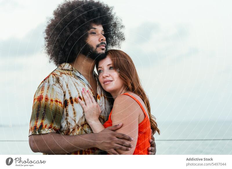 Smiling black couple relaxing near sea under sky embankment happy positive contemplate together smile relationship diverse multiracial young girlfriend