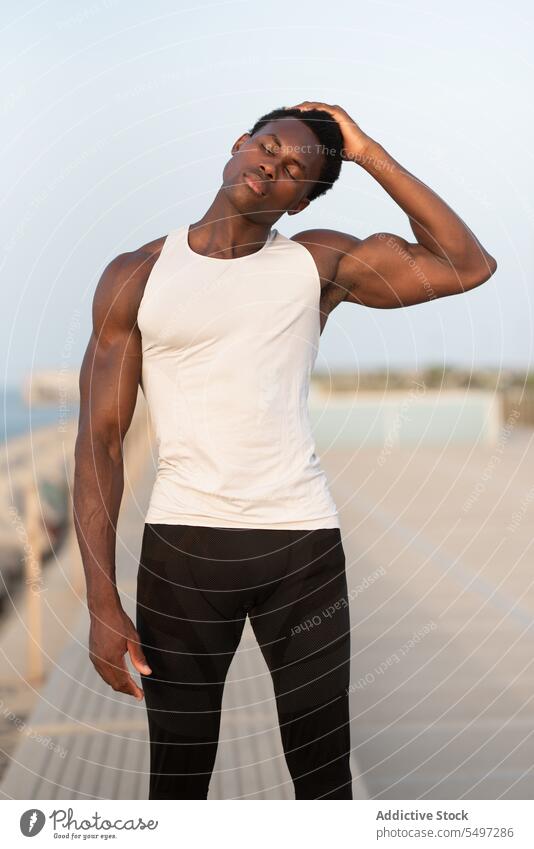 Black man touching head on embankment calm touch head serious sportsman sportswear eyes closed tranquil pensive male thoughtful relax concentrate personality