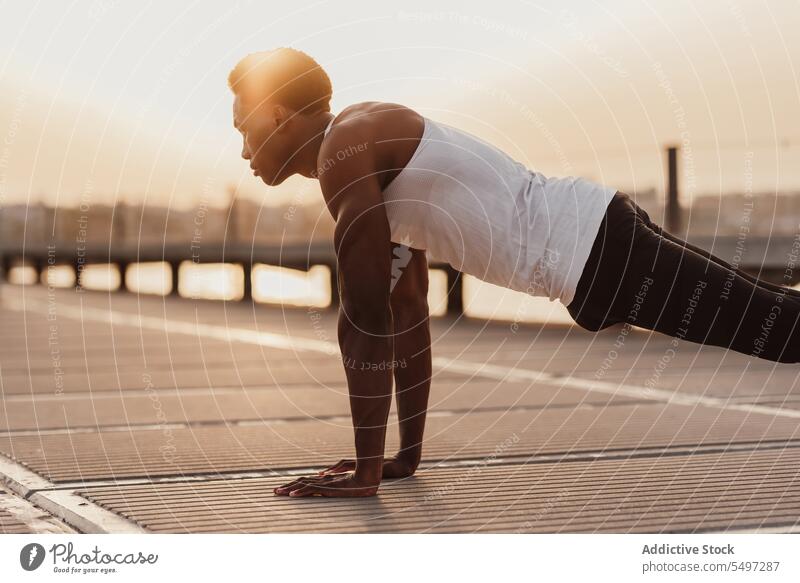 Strong black man doing plank exercise training workout determine athlete sport activity sea male endurance african american sportsman strong sportswear effort