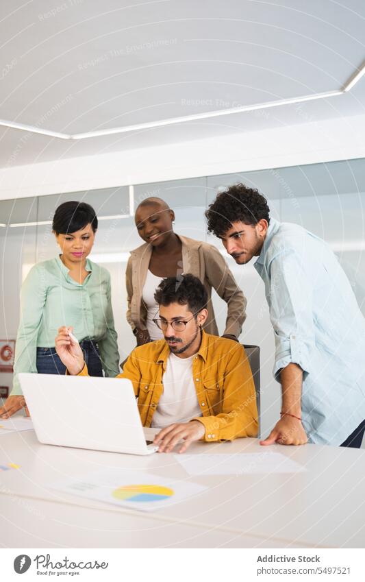 Diverse colleagues working on laptop together coworker using project office gather group business multiracial diverse multiethnic workplace teamwork browsing