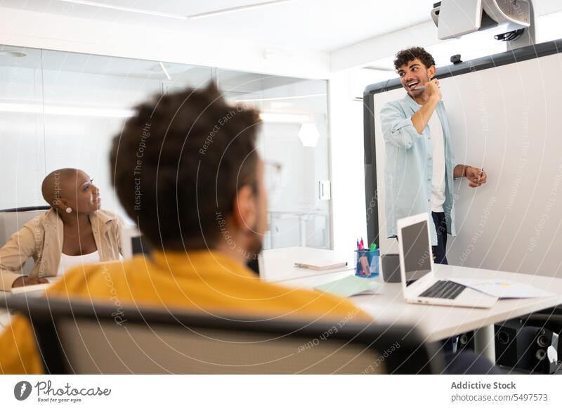 Cheerful man writing on whiteboard write office marker cheerful professional plan take note business male work job project strategy concentrate ethnic creative