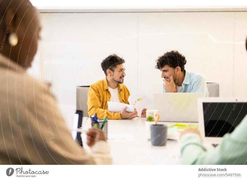 Focused Hispanic man with laptop and documents work using colleague office concentrate browsing workplace male hispanic job busy business employee project