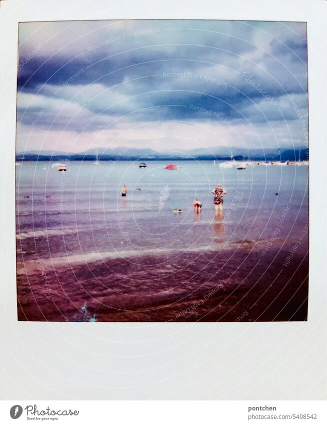 polaroid: a mother stands with her children in swimwear in lake garda Family Toddler splashing Swimming trunks bathe Vacation photo Water Italy