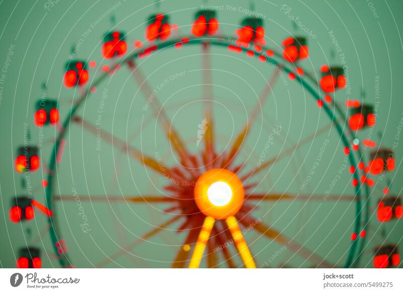 a Ferris wheel turns in green and red Sky Theme-park rides Light (Natural Phenomenon) Circular Design Structures and shapes Silhouette Experimental blurriness