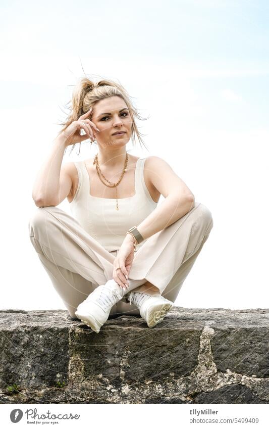 Young woman sitting on a wall. Woman Wall (barrier) Lifestyle free time youthful Blonde Ponytail Joy portrait Happy relaxed Relaxation pretty Attractive